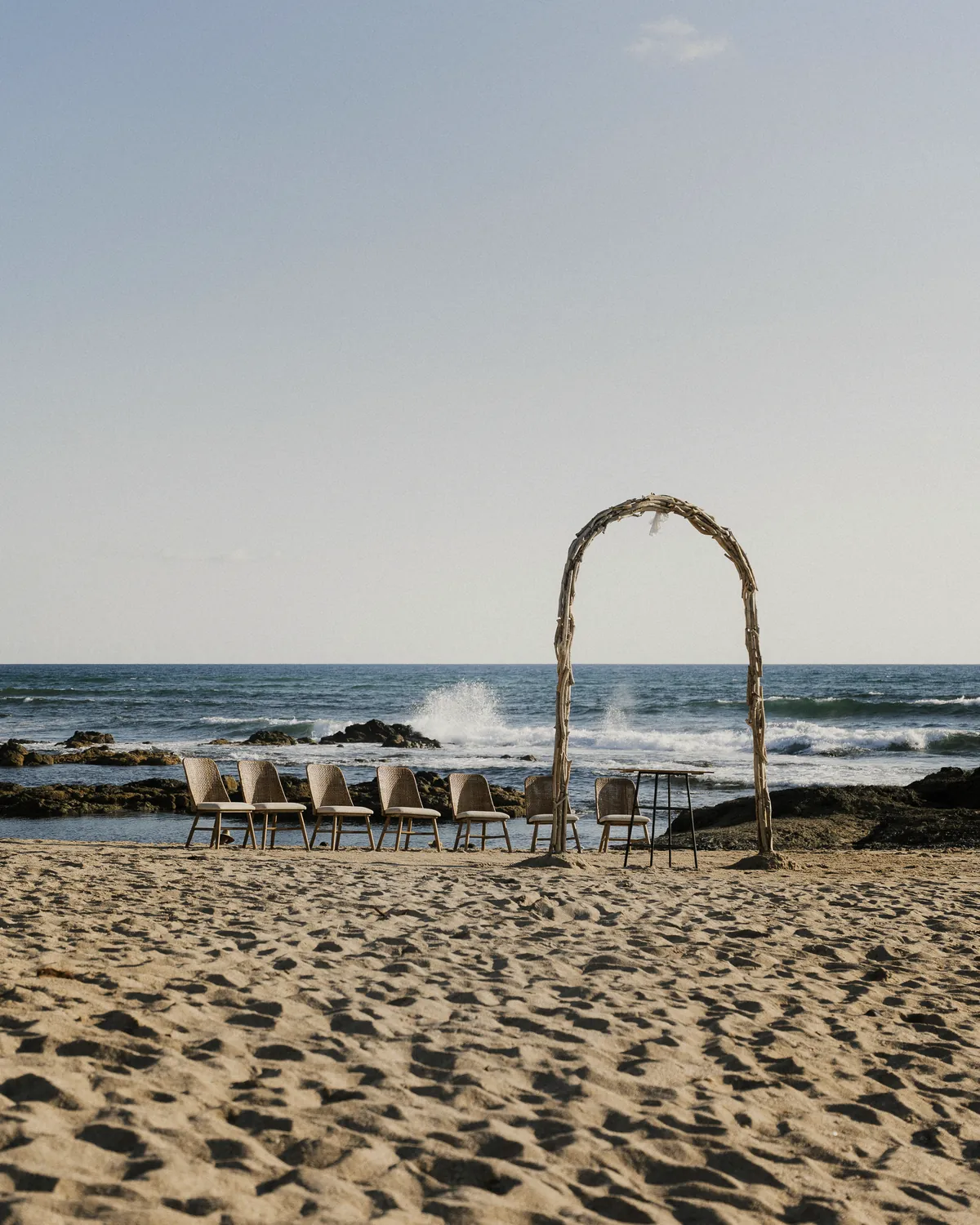 Arco móvil de madera de mar en la playa, preparado para una boda