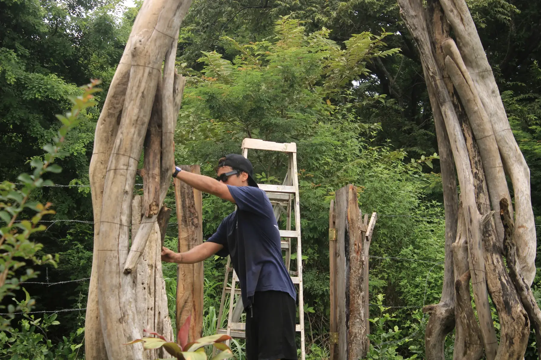 Santiago Imberti levantando los troncos del portal del bosque