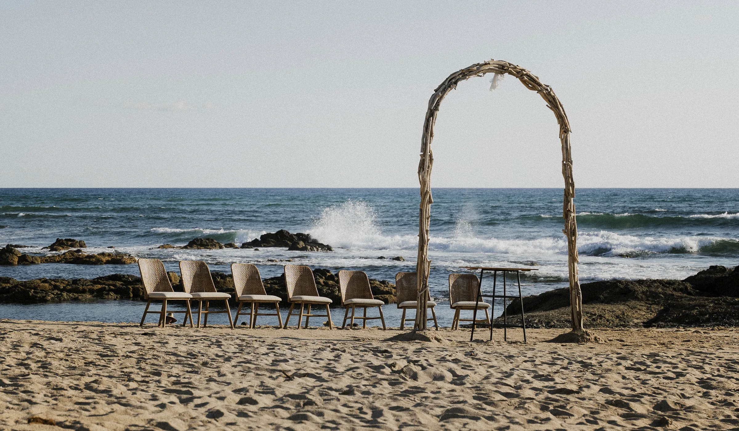Arco móvil de madera de mar preparado para una ceremonia en la playa