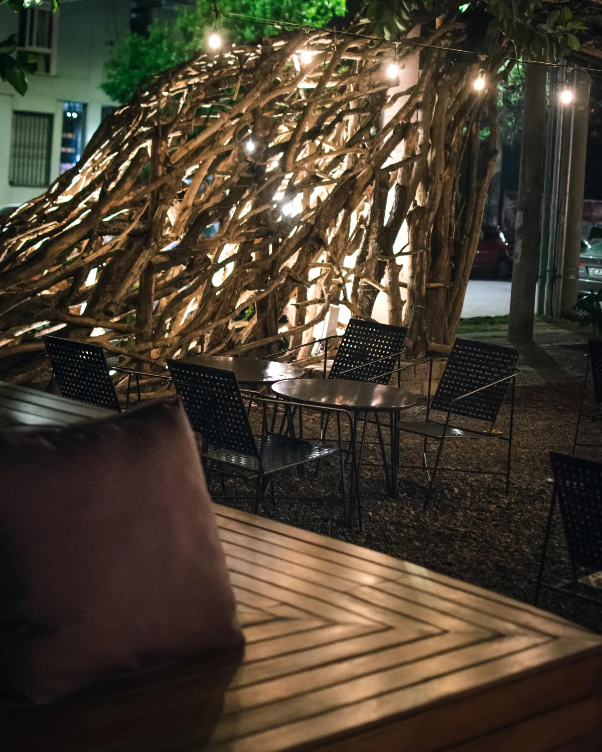 Instalación de ramas sobre la terraza de Ribeca al anochecer
